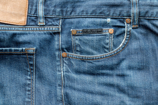 details of worn blue denim jeans pockets with rivets, flat lay