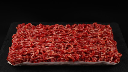 Chopped raw meat  on a black  background.