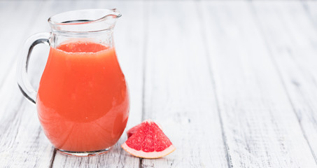 Vintage wooden table with Grapefruit Juice (selective focus)