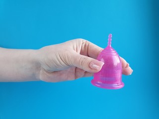 Fototapeta premium latex menstrual Cup in a woman's hand, an alternative hygiene product for women during the menstrual period.