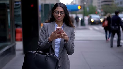 Successful Indian female professional in optical spectacles for vision correction using cellphone for reading received text message and send record audio answer, South Asian woman phoning