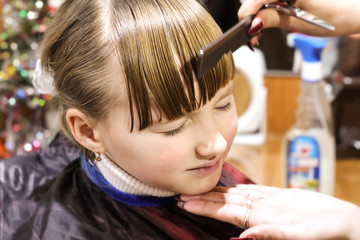 Fototapeta premium A child in a beauty salon on a haircut