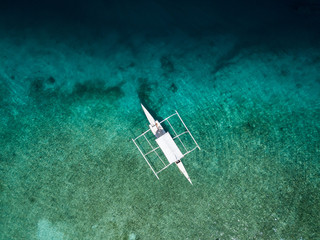 Bird's eye View aerial drone picture of a Bangka Boat in the Crystal Clear Waters of Pamilacan Island, Panglao, Bohol, Philippines