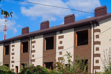 An apartment building under construction with a metal corrugated roof.