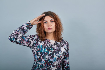 Disappointed attractive caucasian young woman keeping hand on head, looking directly over isolated...