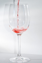 Weinglas befüllen mit Rotwein isoliert auf neutralem Hintergrund