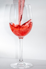 Weinglas befüllen mit Rotwein isoliert auf neutralem Hintergrund