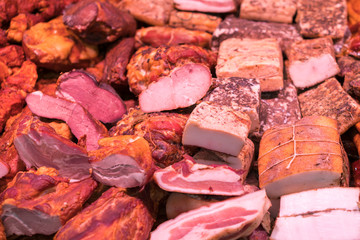 Smoked meat delicacies and sausages on the market balyk of various meats in a shop window. Deli display cold meat and salami. Balyks and various meat delicacies