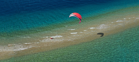 Aerial drone ultra wide photo of kite surfer practising in exotic turquoise sand bar