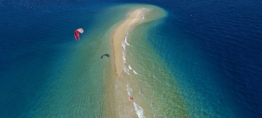 Aerial drone ultra wide photo of kite surfer practising in exotic turquoise sand bar