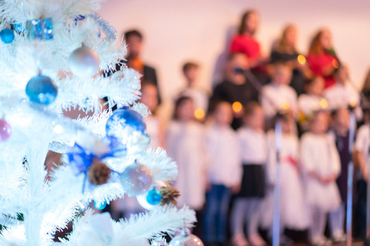 Children's New Year's Choir. Christmas tree and children's choir. Christmas and New Year concept. Blurry