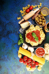 Tasty appetizing classic italian spaghetti pasta with tomato sauce, cheese parmesan and basil and ingredients