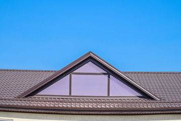 House with plastic windows and a brown roof of corrugated sheet