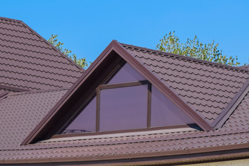 House with plastic windows and a brown roof of corrugated sheet