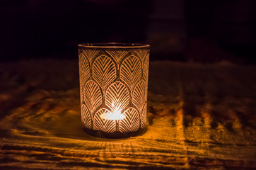 Glass candlestick patterned glowing in the dark .