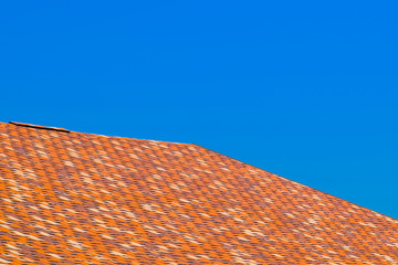 Roof from multi-colored bituminous shingles. Patterned bitumen shingles.