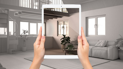 Hands holding tablet showing country living room, kitchen, total blank project background, augmented reality concept, application to simulate furniture and interior design products