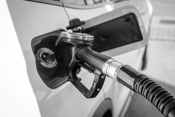 Ein Tankstutzen steckt in der Tanköffnung eines Autos