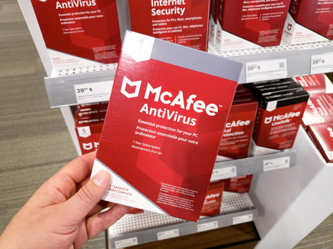 A hand holding McAfee Antivirus box with license and app