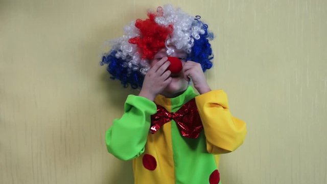 boy dressed as a clown having fun and showing tricks jokes