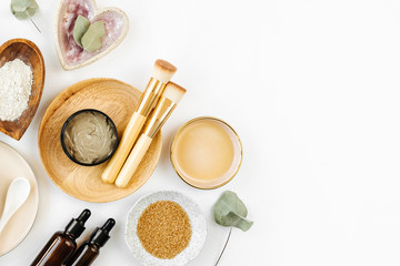 Beauty treatment ingredients for making homemade skin care cosmetic mask. Various bowl with clay, cream, essential oil and natural ingredients  on white table background. Organic spa cosmetic products