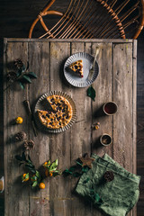 Pie with berries on a wooden table with a serving top view.