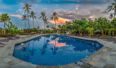 Swimming Pool with Palms at Sunset