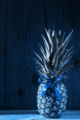 Blue pineapple with bow background. Healthy food ingredients, tropical fruits, diet, slimming vegan foods, weight loss.
