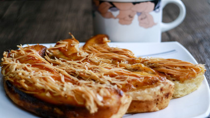 Banana crispy on white plate and a cup of drink with wood background. 