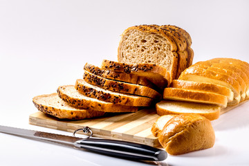 Sliced loaf of sprouting grain and seed bread on a cutting board.