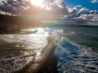 Aerial view of a pier with rocks and rocks on the sea. Pizzo Calabro pier, panoramic view from above. Broken pier, force of the sea. Power of Waves. Natural disasters, climate change. Calabria. Italy