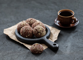 Dessert chocolate cookies with walnuts and coffee on a dark gray background