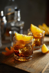 Tasty alcoholic old fashioned cocktail with orange slice.