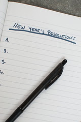 pen and notebook with a list of new years resolutions