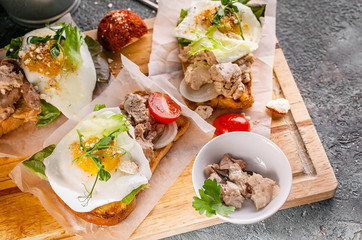 Top view sandwiches with fish pate, herbs and cheese on a wooden cutting board. Close-up
