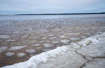 Roundish icy plates floating in coastal waters. Winter landscape in small Nordic country Estonia in late December day. smooth water, far horizon.