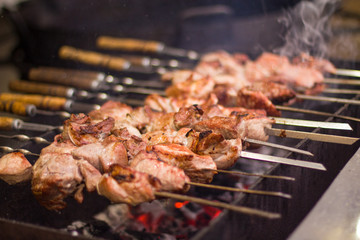  Сooking marinated shashlik,  meat grilling on metal skewer, close up.