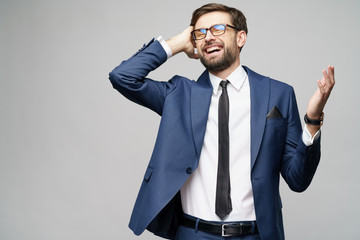 Very happy successful winner gesturing businessman over grey background