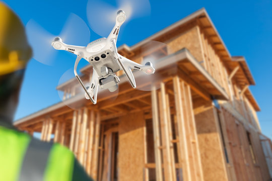 Pilot Flies Drone Quadcopter Inspecting Home Construction Site