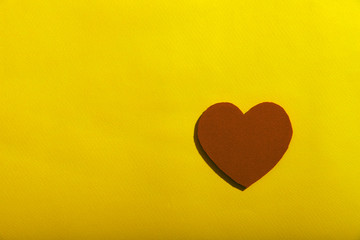 On a yellow background on the right is the figure of a red heart. A lot of free space for text, horizontal, close-up. The concept of health and medicine.