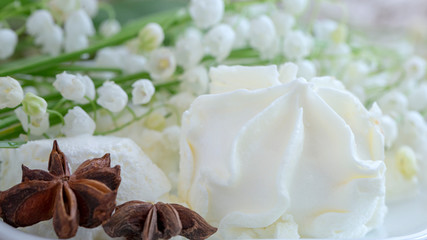 Blurred background, delicate white lilies of the valley and cream ice cream, anise stars