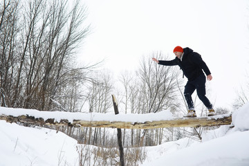 A man in the winter in the forest. A tourist with a backpack goes through the woods in winter. Winter ascent.