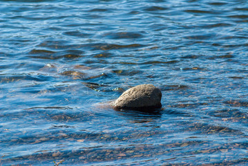 Big stone in clear river water