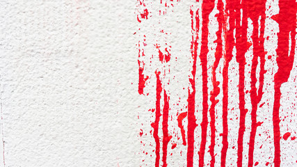  Red paint splatters on rough white wall background