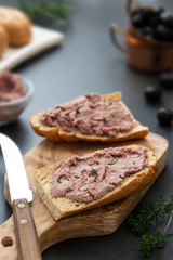Meat chicken or pork liver pate sandwich over wholgrainde bread slices, dark background. Copy space.