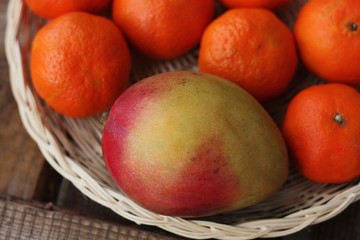 Fresh mango and tangerines on the table