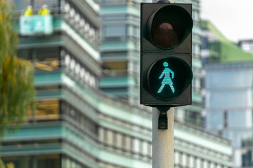 Green pedestrian signal to go. Traffic light female figure shape in Vilnius, Lithuania