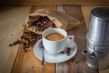coffee in ceramic cup, moka coffee machine, coffee beans and burlap sack on wooden background