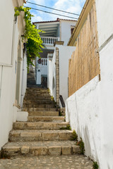Fototapeta na wymiar Steep entrance via stairs between white buildings.