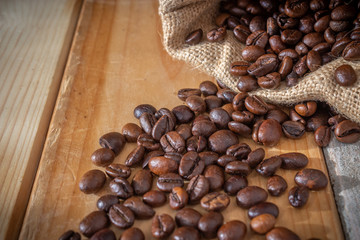 coffee beans and burlap sack on wooden background